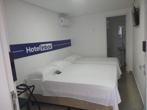 a bed in a hotel room with a sign on the wall at Hotel In Box - Roseira in Roseira