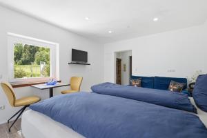 a bedroom with two blue beds and a window at Schwarzwald Ledi - Bed & Breakfast Feldberg in Feldberg
