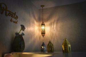 a light hanging from a wall with vases on a shelf at HoneyPath Atlas Retreat in Agadir