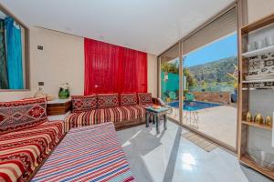 a living room with red furniture and a large window at HoneyPath Atlas Retreat in Agadir
