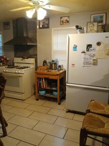 a kitchen with a refrigerator and a stove and a table at Private room in Omaha
