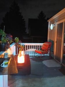 a patio with a bench and a chair on a porch at night at Private room in Omaha