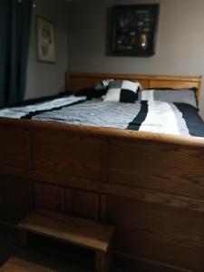 a wooden bed with a black and white comforter at Private room in Omaha