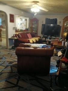 a living room with two couches and a television at Private room in Omaha