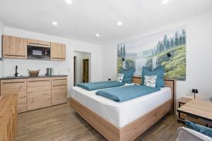 a bedroom with a large bed with blue pillows at Schwarzwald Ledi - Bed & Breakfast Feldberg in Feldberg