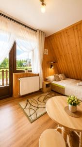 a hotel room with a bed and a table and a table sidx sidx at Willa POŚREDNIA - widok na Tatry z każdego pokoju in Zakopane