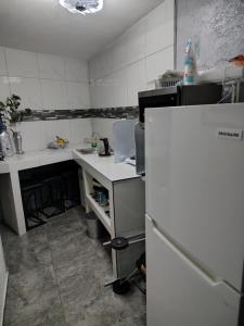 a kitchen with a white counter and a refrigerator at El Rinconcito in Santa Ana