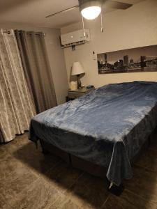 a bedroom with a large bed with a blue blanket at El Rinconcito in Santa Ana +1 photo