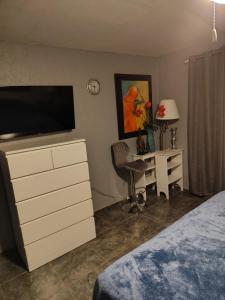 a bedroom with a television and a desk with a chair at El Rinconcito in Santa Ana