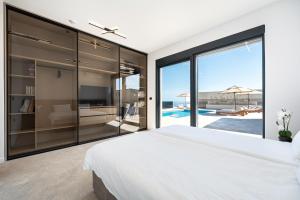 a bedroom with a large white bed and a view of the ocean at Krimovica Villas in Budva