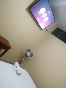 a bathroom with a toilet and a tv on the wall at Hospedaje San Valentin in Capitan Concha