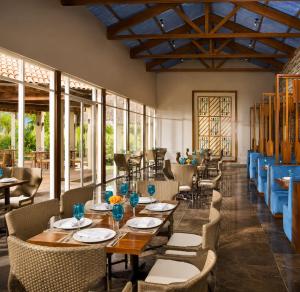 a restaurant with tables and chairs and windows at Luxury Beachfront Condo at Krystal Grand Resort - NEWLY REMODELED & NEWLY FURNISHED in Bucerías
