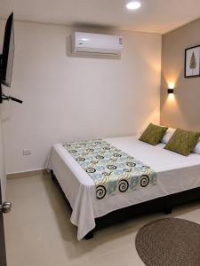 a bedroom with a bed and a air conditioner at Hostal Caiman Del Rio in Barranquilla