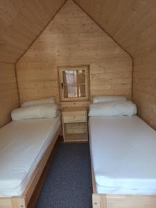 two beds in a cabin with a window at Happy House Hel in Hel