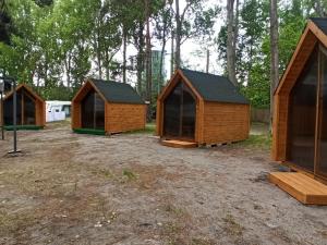 a row of wooden huts sitting in a field at Happy House Hel in Hel