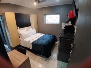 a small bedroom with a bed and a window at Gaia Hydro-Spa and Guest House in Cape Town