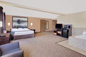 a large hotel room with a bed and a tub at Super 8 by Wyndham Lebanon in Lebanon