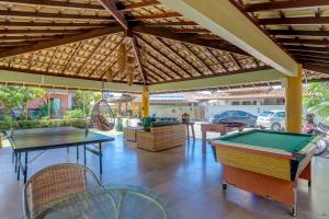 a patio with two ping pong tables and awning at Pousada Praia Bela in Ilhéus