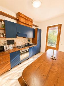a kitchen with blue cabinets and a wooden table at Casa Campomonte 2 in Poppi Stazione
