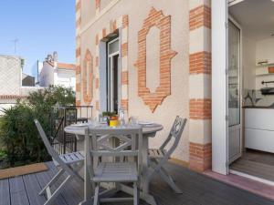 a table and chairs on the balcony of a building at Parenthèse en Ville in Arcachon