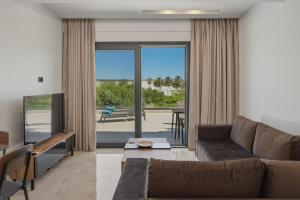 a living room with a couch and a view of a patio at Aurelia Luxury House in Amoudara Herakliou