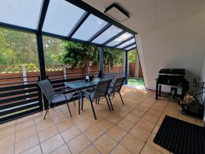 a screened in porch with a table and chairs at Bukowy Domek Całoroczny in Sieraków