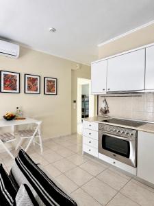 a kitchen with white cabinets and a stainless steel oven at Agapidis Apartment in Hanioti