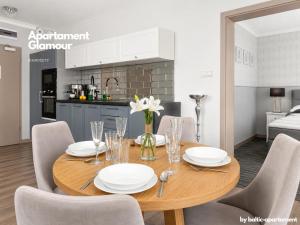 a dining room with a wooden table and chairs at Apartament Glamour - 5 Mórz - Basen - SPA - Sauna in Sianozety