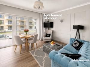 a living room with a blue couch and a table at Apartament Glamour - 5 Mórz - Basen - SPA - Sauna in Sianozety