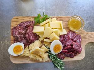 a cutting board with cheese and other foods on it at Tällihütte in Gadmen