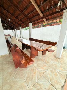 a wooden table and a bench in a room at casa em jacumã in Conde