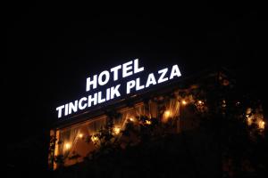 a sign for a hotel timikoku plaza at night at Tinchlik Plaza in Urganch