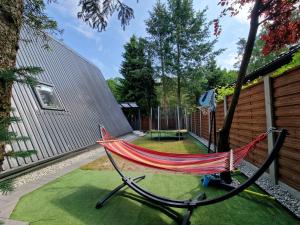 a hammock in the backyard of a house at Bukowy Domek Całoroczny in Sieraków +17 photos