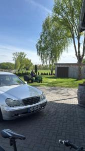 a white car parked in a parking lot with bikes at Ferienwohnung Spreewald in Schlepzig +2 photos