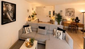 a living room with a couch and a table at Le Aix Rotonde Mirabeau - Centre Ville Terrasse Garage in Aix-en-Provence