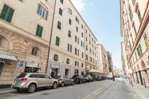a city street with cars parked next to tall buildings at "Cà Niella" in centro e a 9 m dal mare in Savona