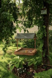 a wooden structure with a covering on a tree at Árnyaskert Vendégház in Békésszentandrás