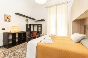 a hotel room with two beds and a desk at "Cà Niella" in centro e a 9 m dal mare in Savona