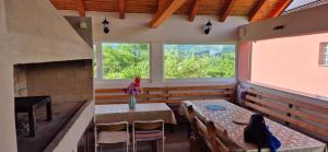 a room with a table and chairs and a fireplace at Villa Miševići in Hadžići