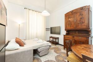 a bedroom with a bed and a wooden cabinet and a table at "Cà Niella" in centro e a 9 m dal mare in Savona