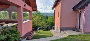 a pink house with a view of a yard at Villa Miševići in Hadžići +26 photos