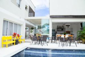an outdoor patio with tables and chairs and a pool at Hotel e Pousada VIVÁ in Chapada dos Guimarães