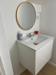 a white bathroom with a mirror and a sink at Apartament przy Agorze in Bytom