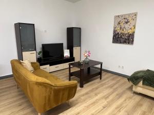 a living room with a couch and a tv and a table at Apartament przy Agorze in Bytom