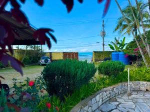 a garden with a view of the ocean at Pousada Cantinho do Mar - pé na areia in Guarujá