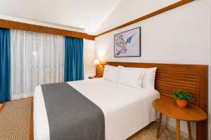 a hotel room with a large bed and a table at Blue Tree Thermas de Lins Resort in Lins