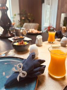 a table with a plate of food and a glass of orange juice at B&B Prachtig Allemachtig in Valkenburg