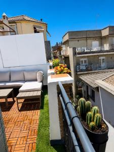a balcony with a couch and cactus on a building at Penthouse San Isidro 3 suites Terraza Privada Parking in Granada
