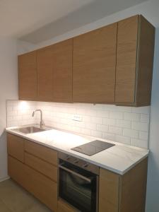 a kitchen with wooden cabinets and a sink at Apartment Stiniva in Hvar