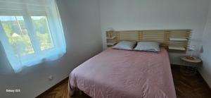 a small bedroom with a bed with a window at Maison d' Adèlbraz in Voulaines